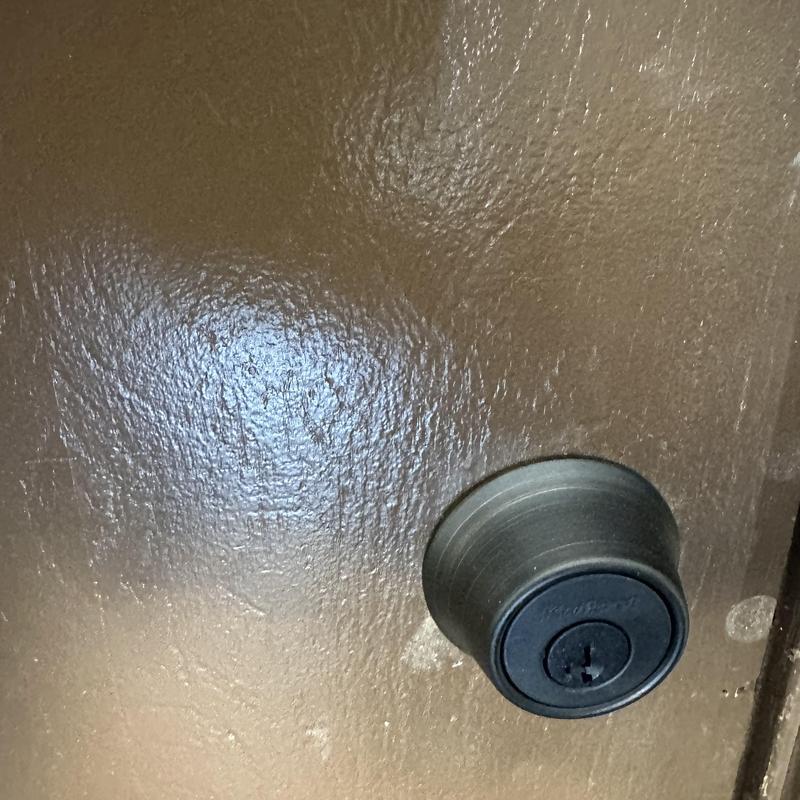 Deadbolt lock installation on brown door in Tulsa