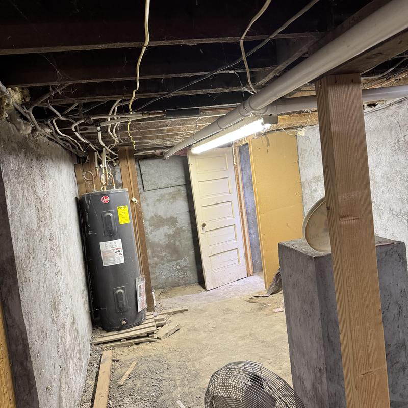 Water heater in unfinished basement with exposed wiring