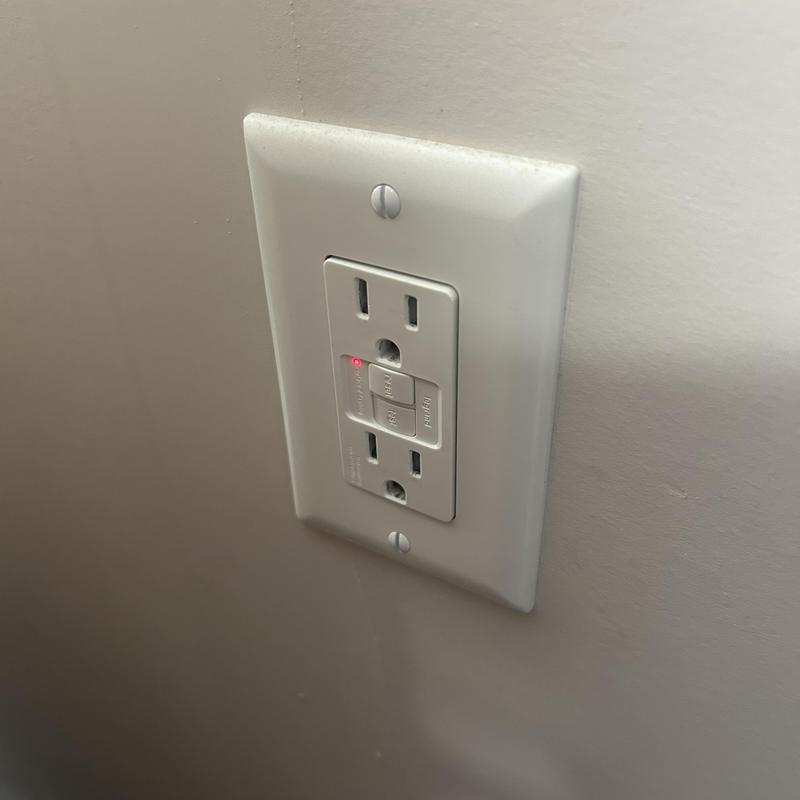 GFCI electrical outlet with reset button and indicator light