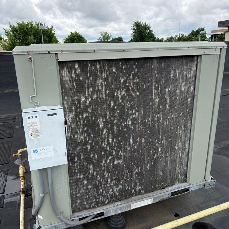 HVAC condenser coil with visible corrosion on rooftop unit