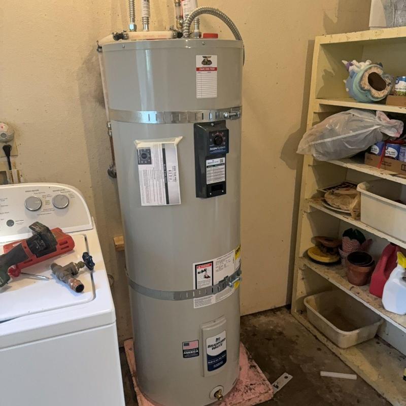 50-gallon electric water heater installation in utility room