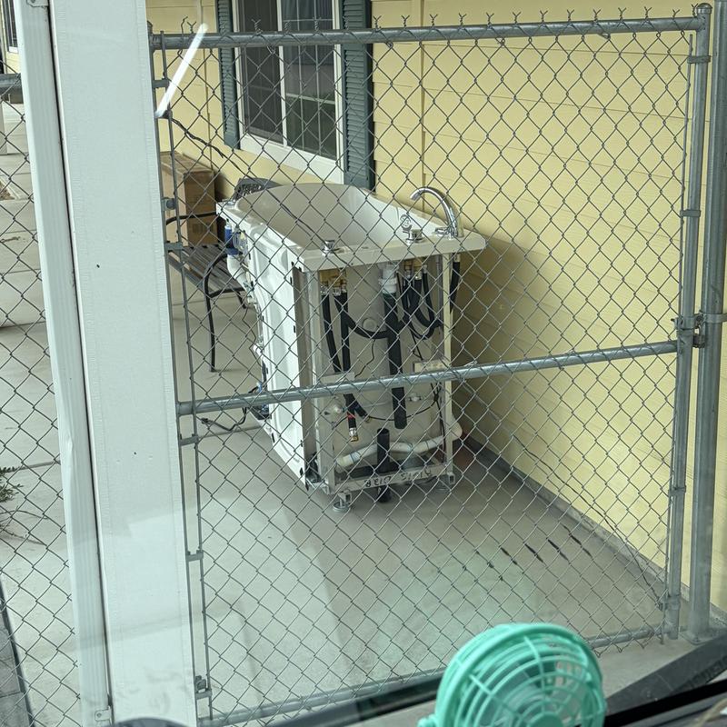 Kohler Sterling bathtub with plumbing exposed behind fence
