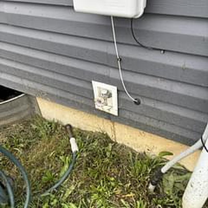 Hose bib installation on house exterior wall with garden hose Hose bib installation on house exterior wall with garden hose