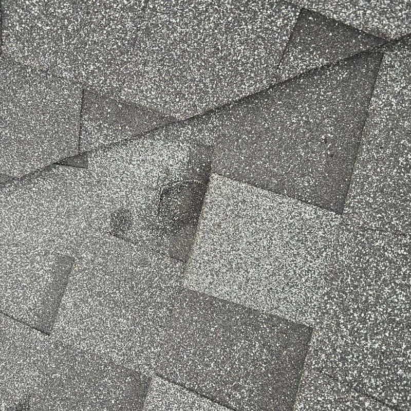 Roof shingles with visible hail damage spot