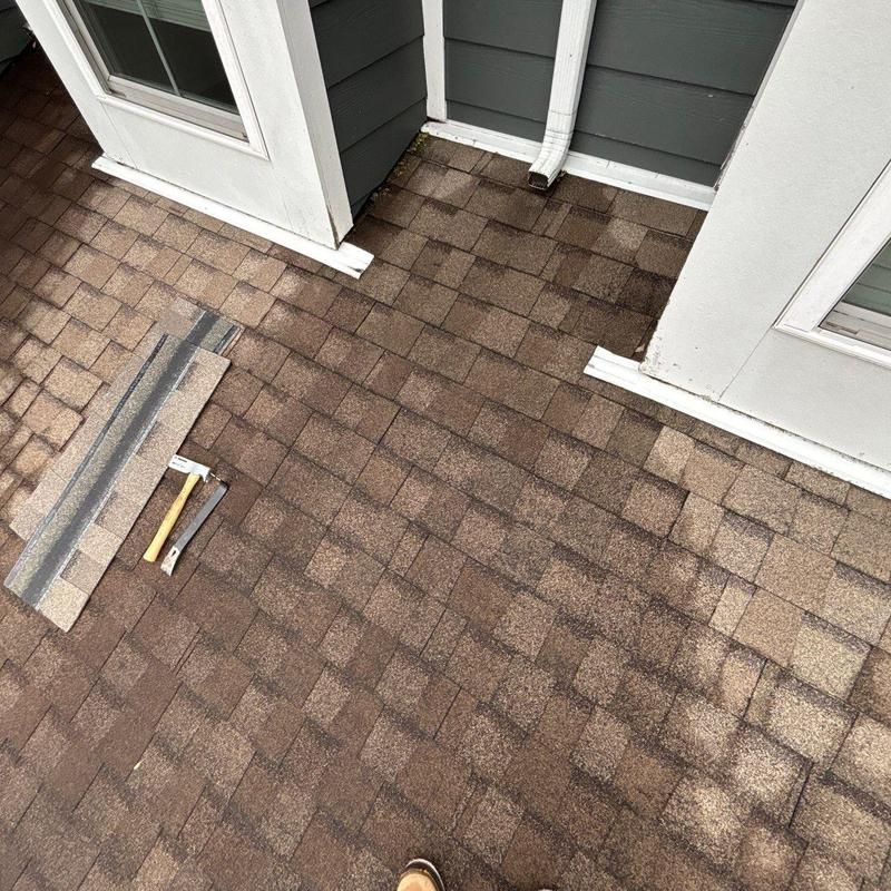 Asphalt shingle roof with hail damage near flashing and vents