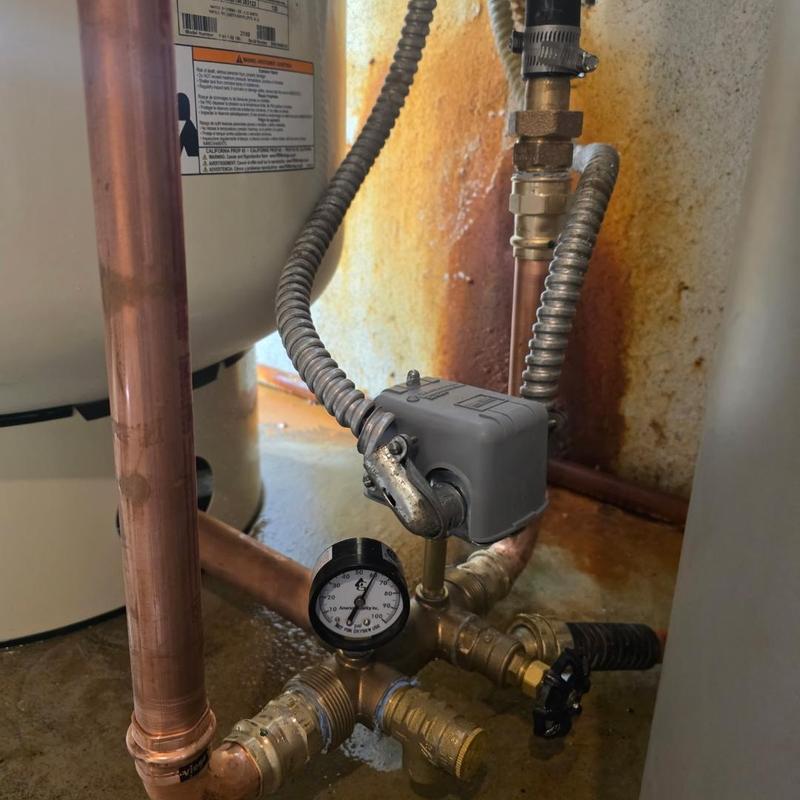 Pressure switch and gauge on copper piping near tank