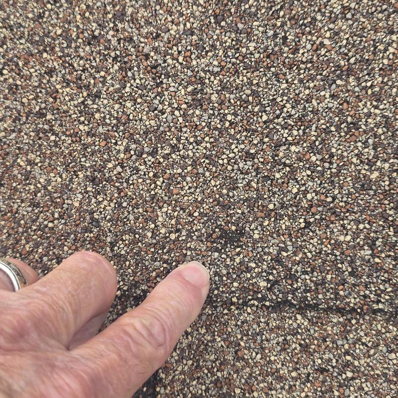 Asphalt shingle roof with hail damage spot