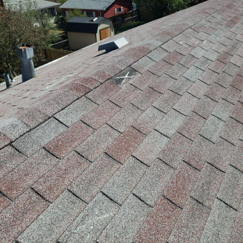 Asphalt shingles with marked wind damage on roof Asphalt shingles with marked wind damage on roof