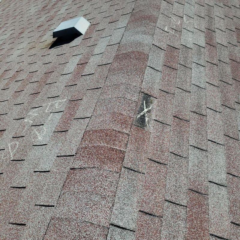 Wind-damaged asphalt shingles with chalk markings Wind-damaged asphalt shingles with chalk markings