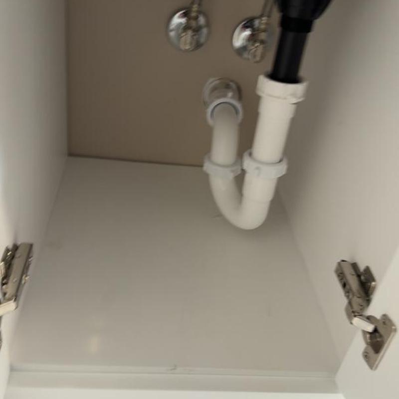 Bathroom sink drain pipes and shutoff valves under cabinet