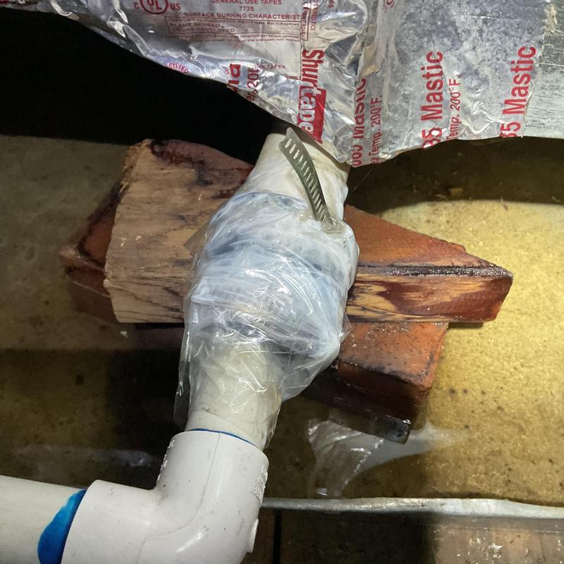 Condensate drain line joint wrapped with plastic and clamp Condensate drain line joint wrapped with plastic and clamp