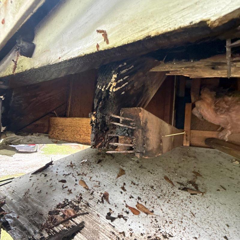 Roof framing fire damage with charring and nails exposed Roof framing fire damage with charring and nails exposed