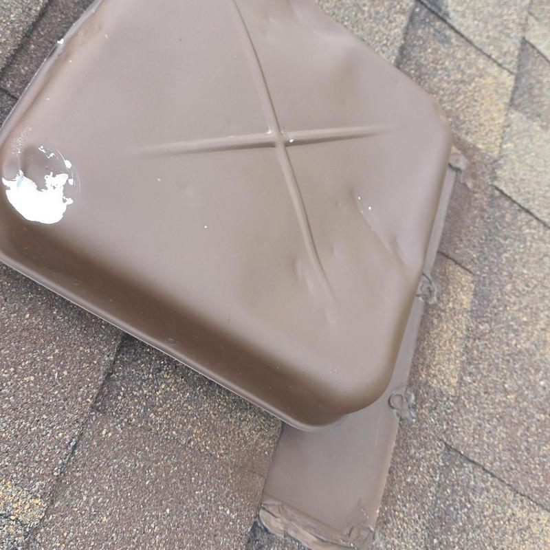 Metal roof vent with hail damage dents on shingles