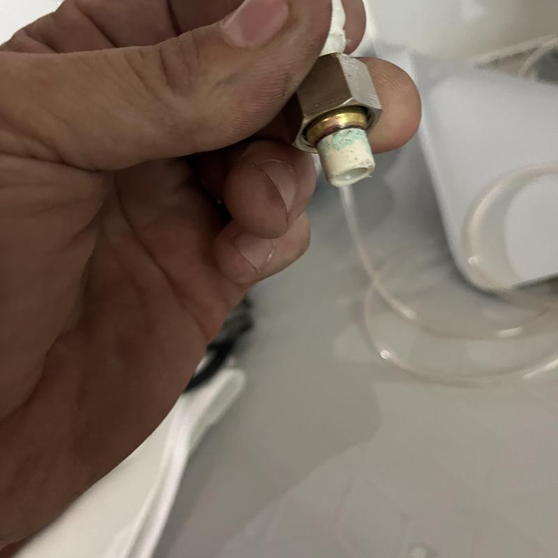 Icemaker waterline fittings held in hand for repair