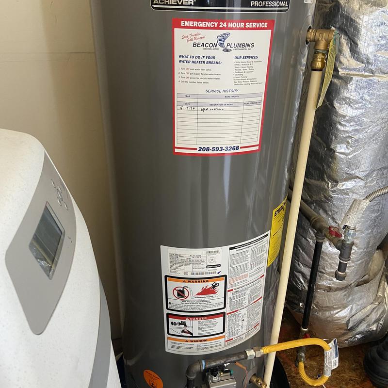 Water heater with warning labels and plumbing connections