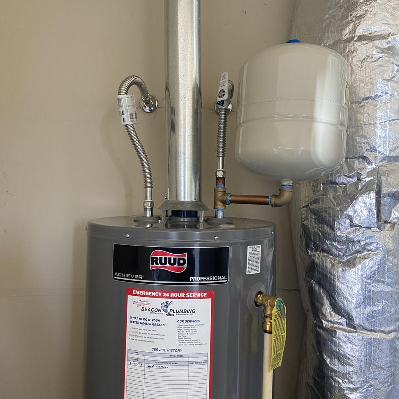 Water heater with pressure tank and vent pipe in garage