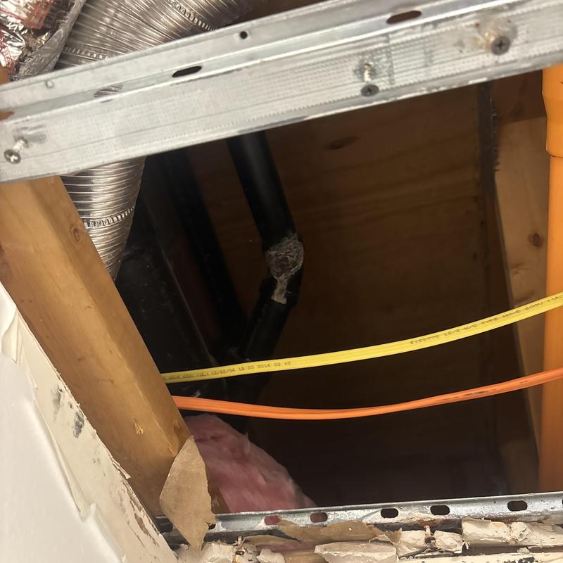 PVC drain pipe with insulation and wiring above ceiling