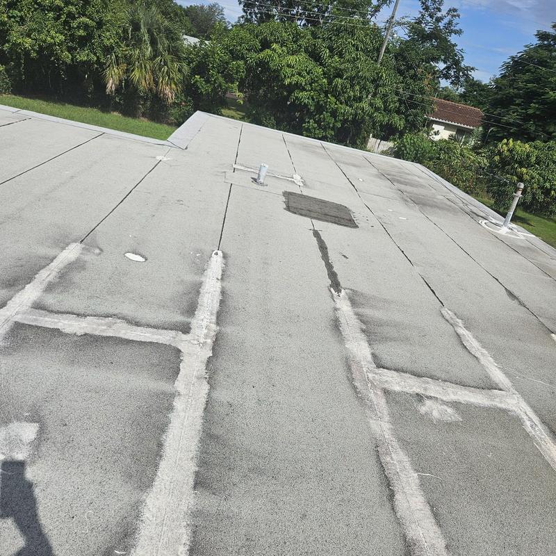 Flat roof membrane with patched leak areas and damage Flat roof membrane with patched leak areas and damage