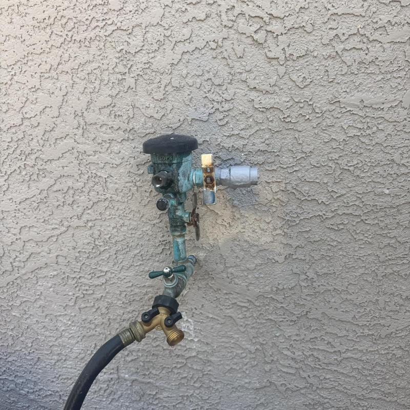 Pressure vacuum breaker with hose bib on stucco wall