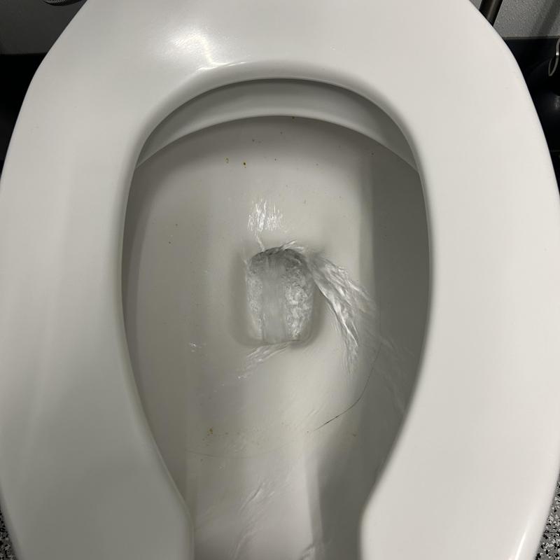 Toilet bowl flushing water flow in commercial property restroom