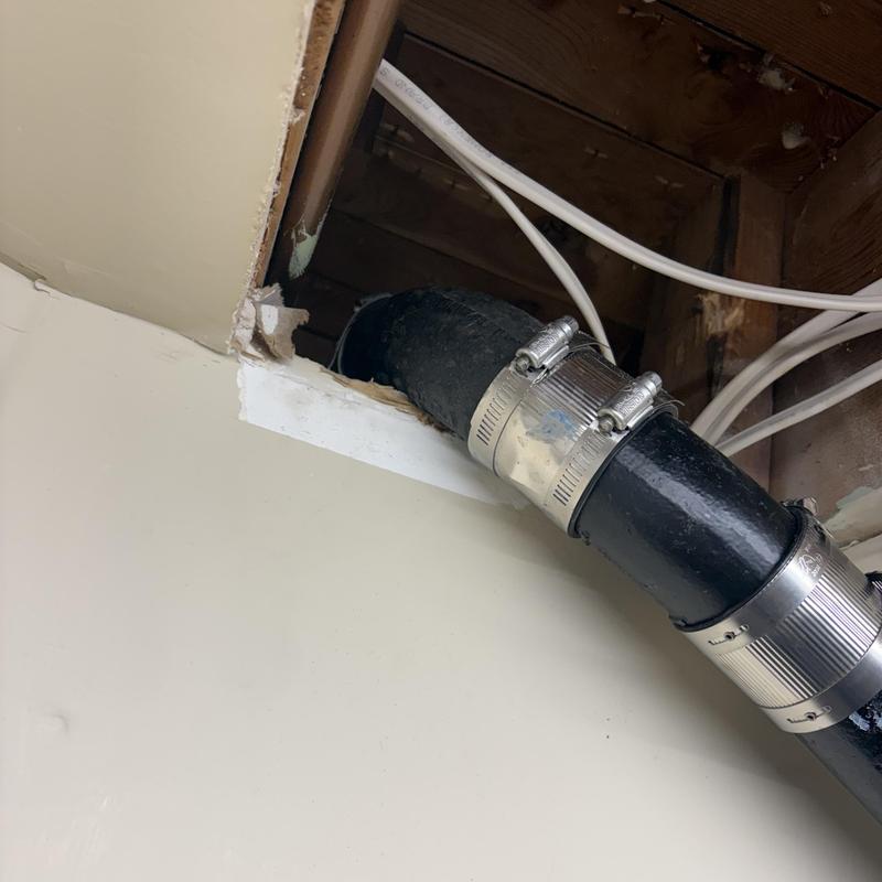 Cast iron drain pipe with clamp couplings in ceiling cavity