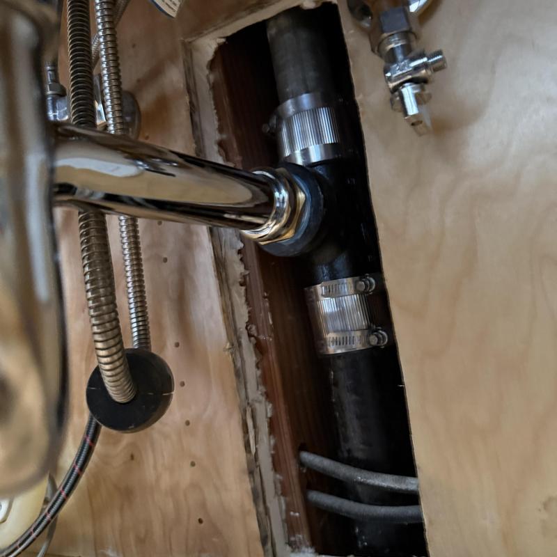 Cast iron drain pipe with new fittings under kitchen sink
