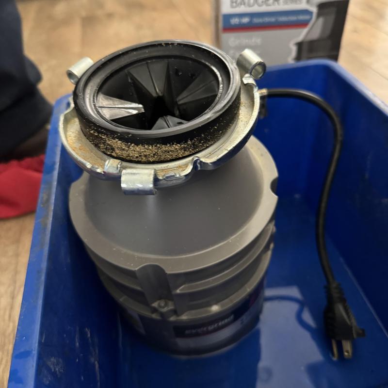 Garbage disposal unit in blue service tub with power cord