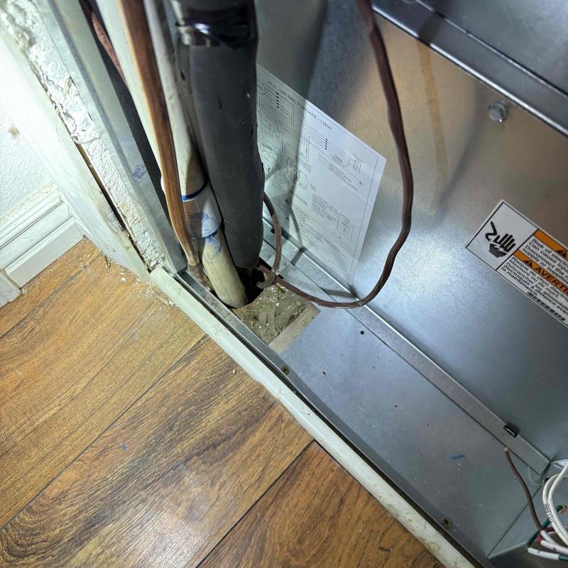 Blue poly water service pipe near HVAC unit and floor