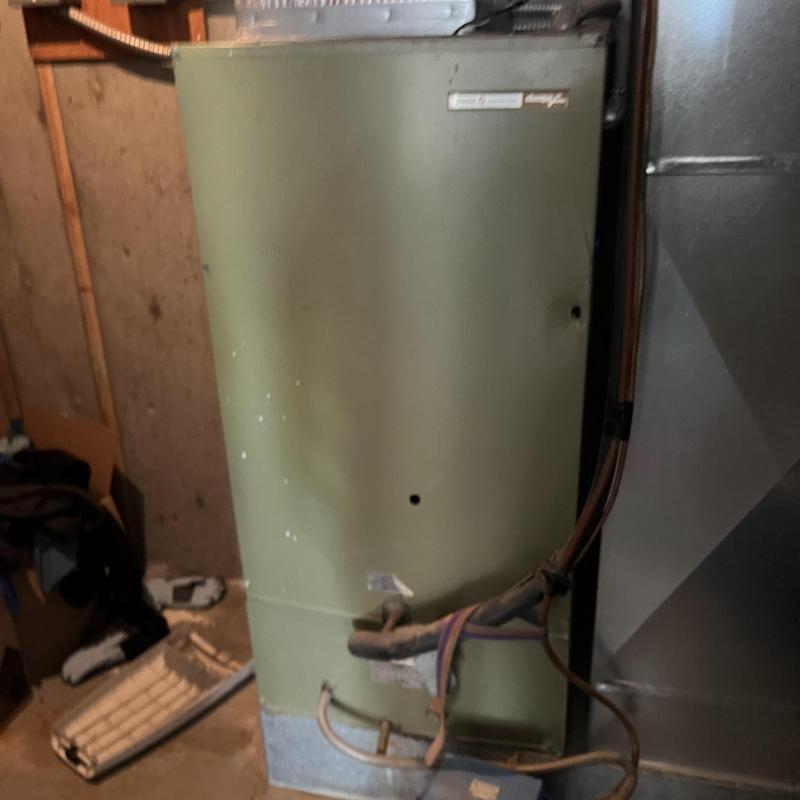 Old HVAC air handler unit with copper piping in basement