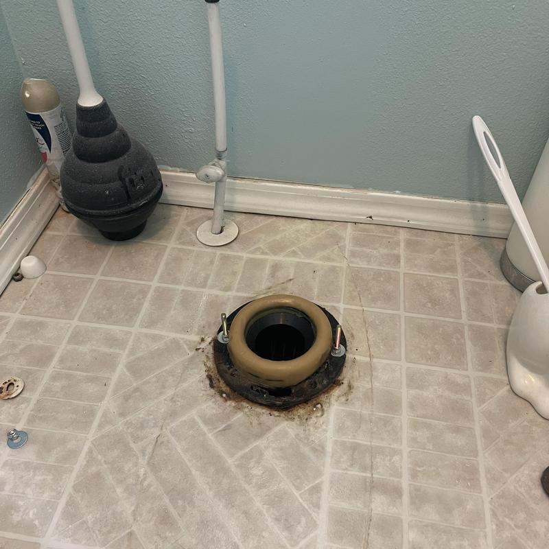 Toilet flange with new wax ring on bathroom floor
