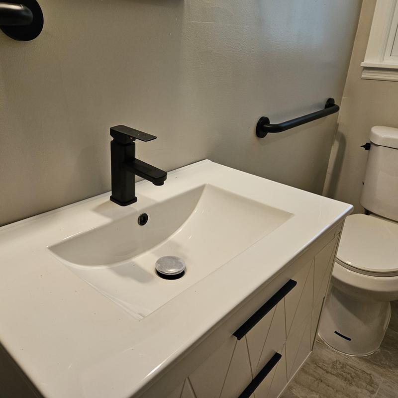Bathroom sink with black faucet and grab bar Bathroom sink with black faucet and grab bar