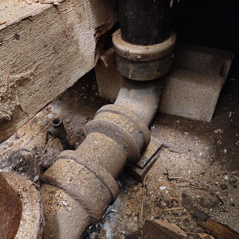 Cast iron sewer stack pipe under bathroom floor
