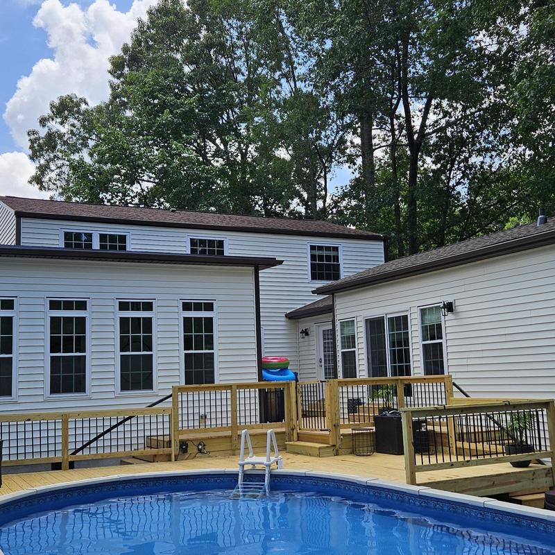 Above-ground pool with custom wooden deck and railing Above-ground pool with custom wooden deck and railing