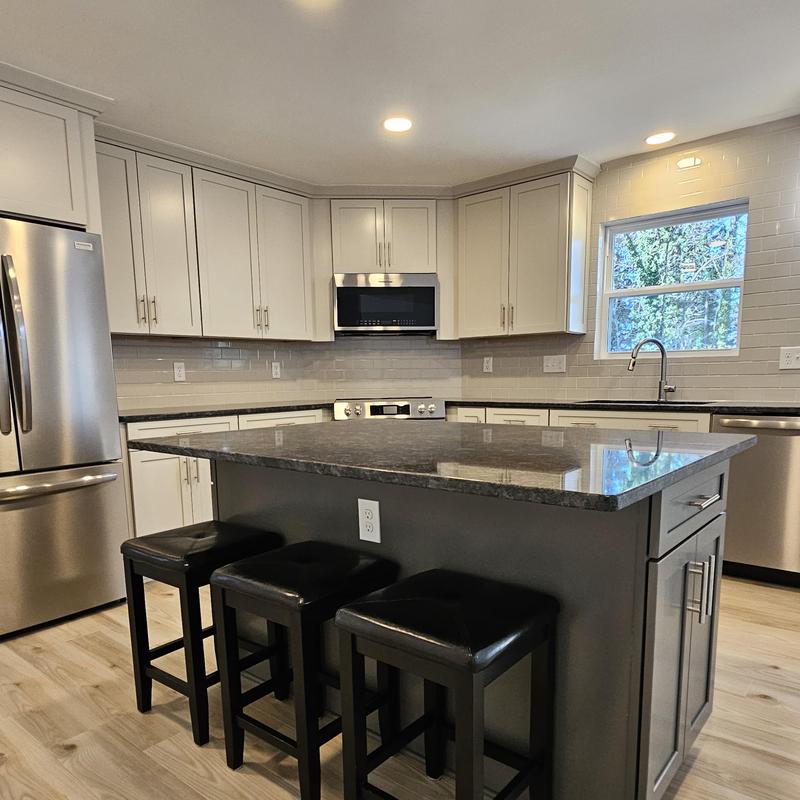 Kitchen island with granite countertop and seating stools Kitchen island with granite countertop and seating stools