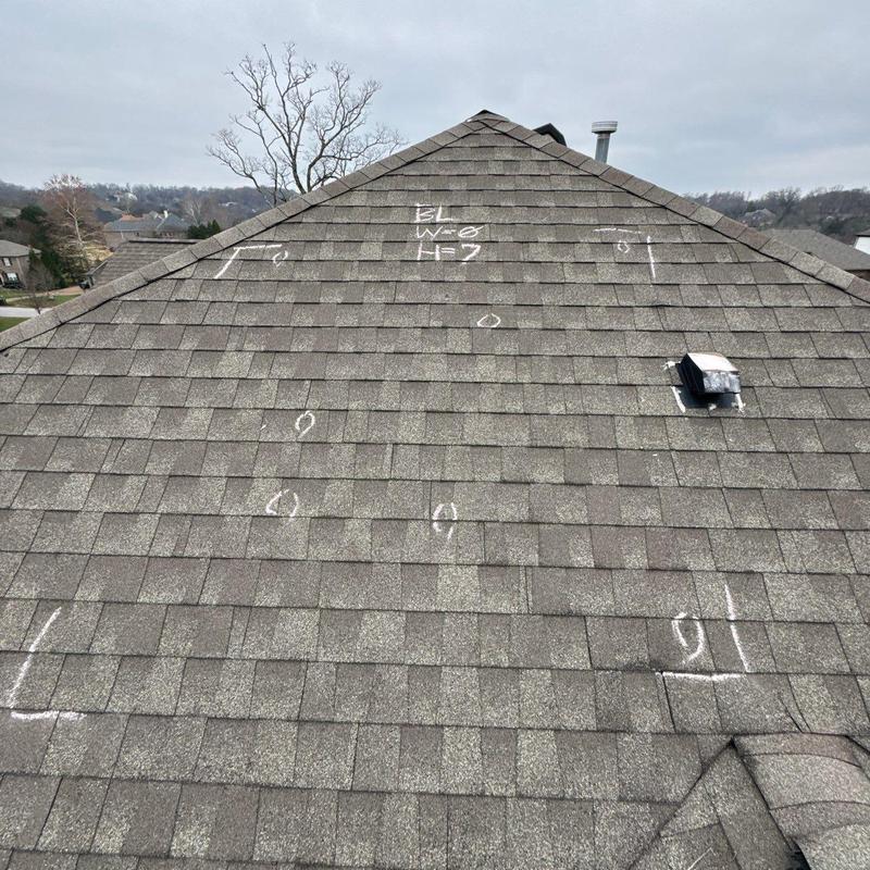 Roof shingles with hail damage marked for inspection