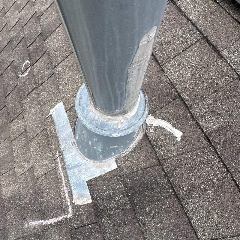 Flashing around roof vent with hail damage marks