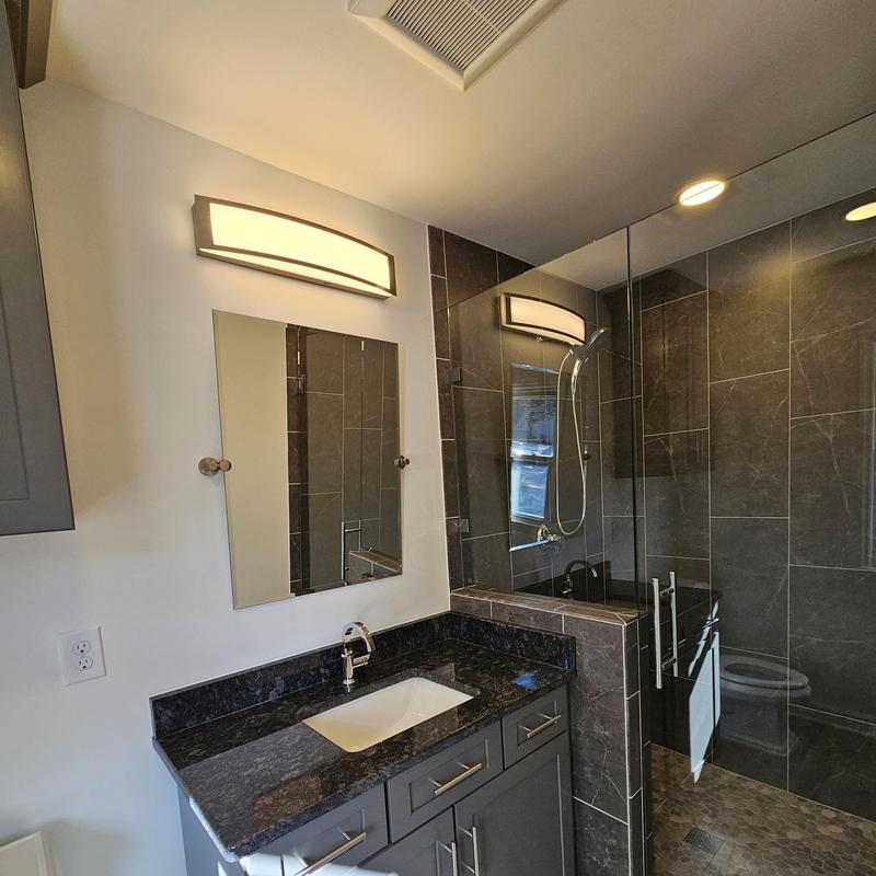 Bathroom vanity with granite countertop and glass shower enclosure Bathroom vanity with granite countertop and glass shower enclosure