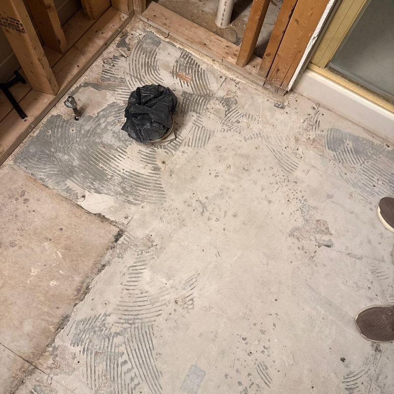 Concrete subfloor with pipe rough-in and tile adhesive