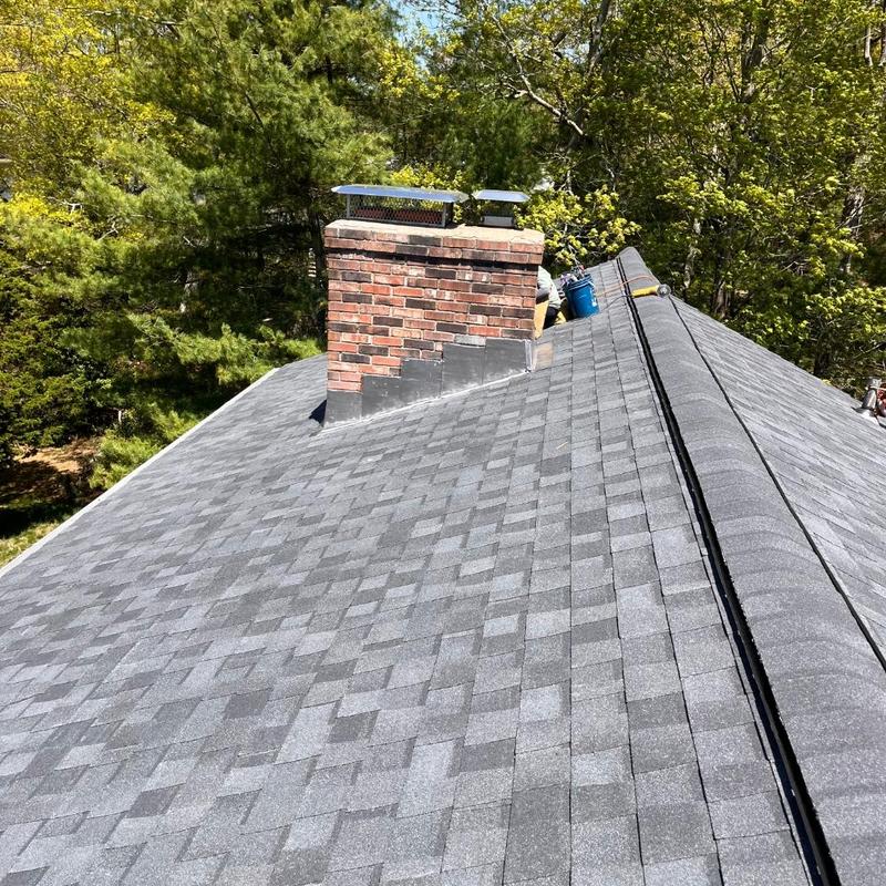 Asphalt shingle roof with brick chimney and flashing Asphalt shingle roof with brick chimney and flashing
