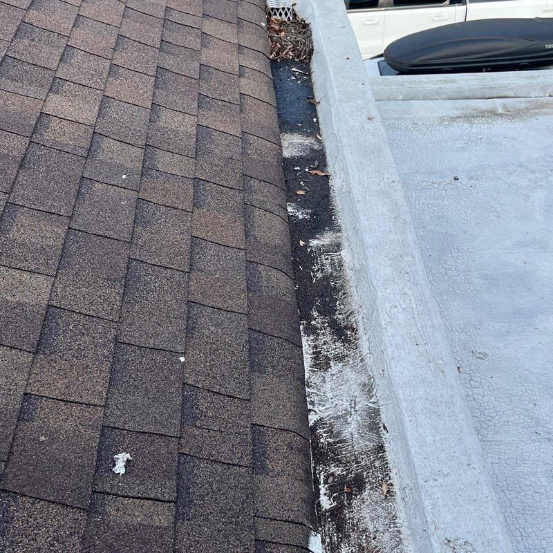 Asphalt shingle roofing with metal flashing on flat roof edge