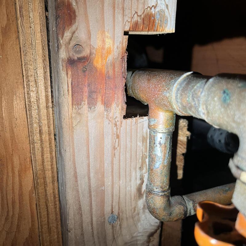 Copper plumbing pipe with corrosion in crawlspace