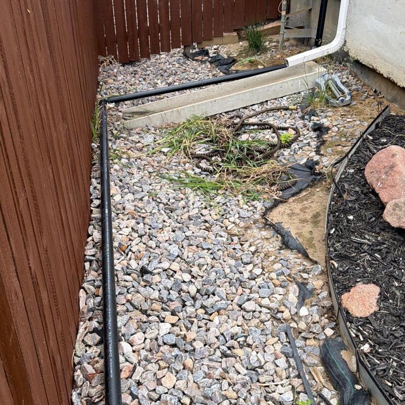 Downspout drainage pipe extension on gravel yard Downspout drainage pipe extension on gravel yard