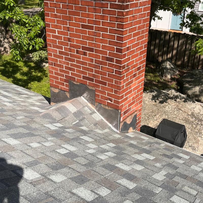 Asphalt shingle roof with brick chimney flashing installation Asphalt shingle roof with brick chimney flashing installation