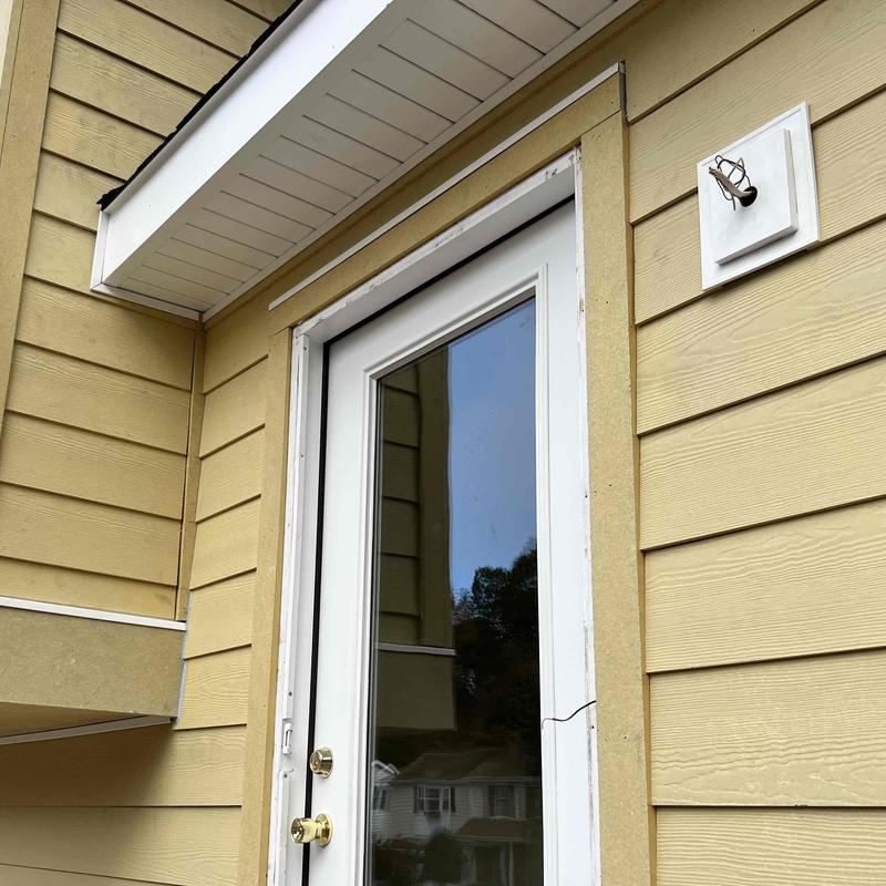 Glass door with cracked frame and yellow siding paneling Glass door with cracked frame and yellow siding paneling