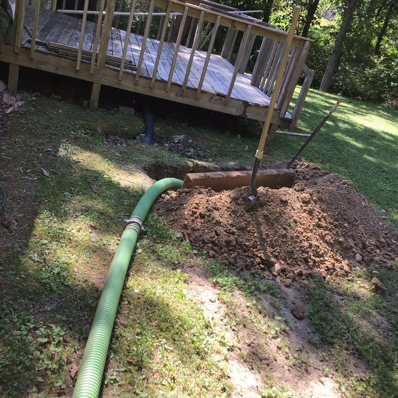 Septic tank with green pump hose and soil mound