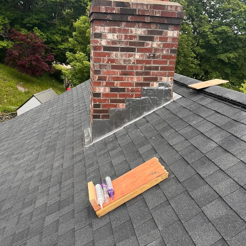 Roof chimney flashing with black asphalt shingles Roof chimney flashing with black asphalt shingles