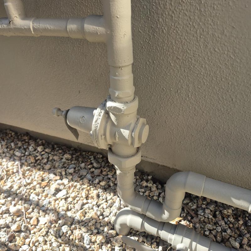 Gas regulator valve with connected piping outdoors