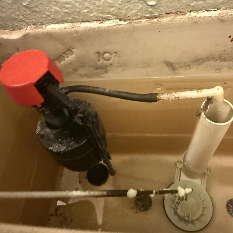 Toilet fill valve with red cap inside tank
