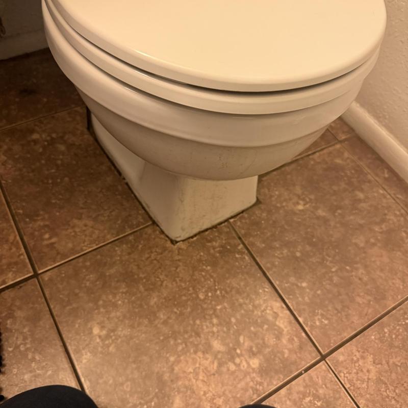 Toilet base with tiled floor in bathroom corner