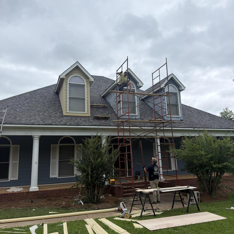 Dormer siding installation on front house with scaffolding